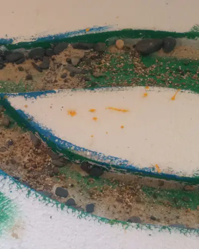 Base de poliestireno en proceso: recorte del cauce con pintura verde y azul